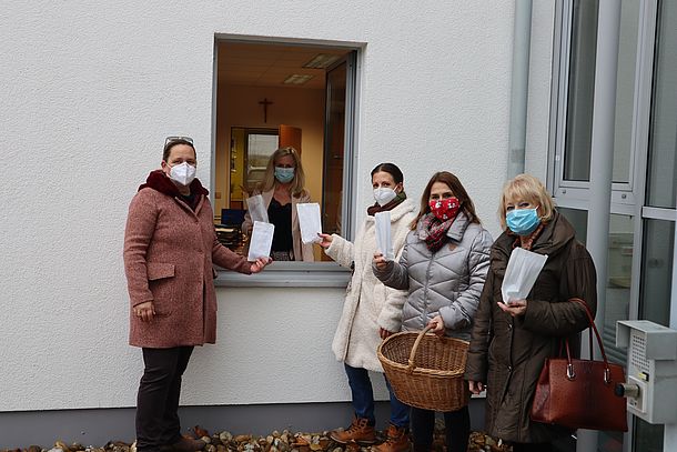 Personen stehen bei einem Fenster